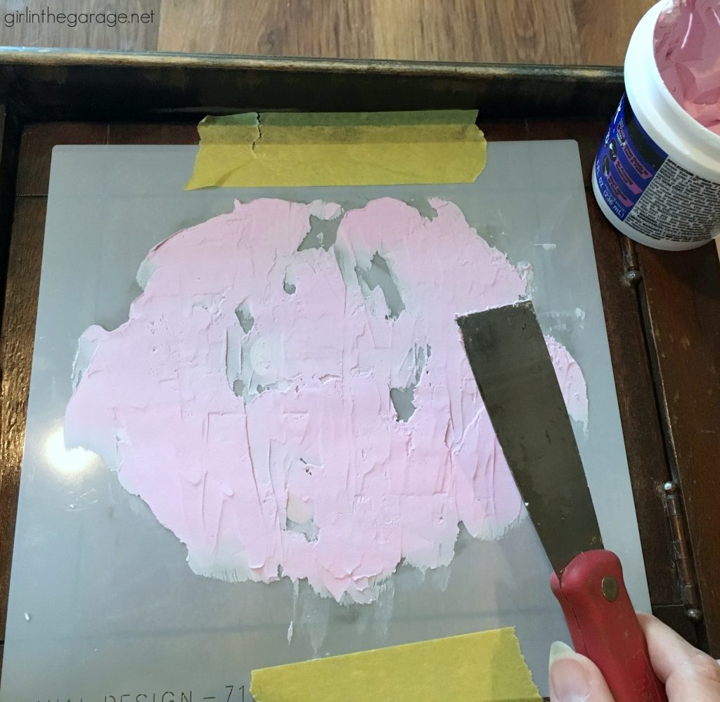 Add amazing custom texture with a raised stencil furniture makeover using spackling from the hardware store. Step by step DIY tutorial for embossed furniture by Girl in the Garage.