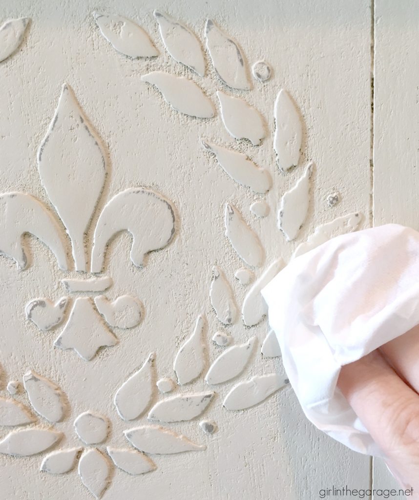 Add amazing custom texture with a raised stencil furniture makeover using spackling from the hardware store. Step by step DIY tutorial for custom embossed furniture by Girl in the Garage.