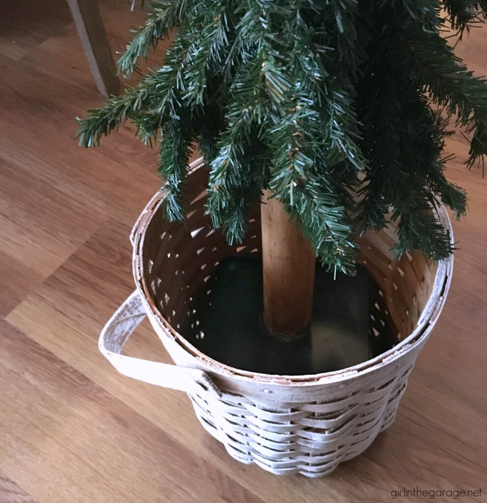 For cozy Christmas decor, learn how to use a thrifted basket as a DIY Christmas tree basket stand. An easy project with beautiful results. DIY furniture makeover and decor ideas by Girl in the Garage