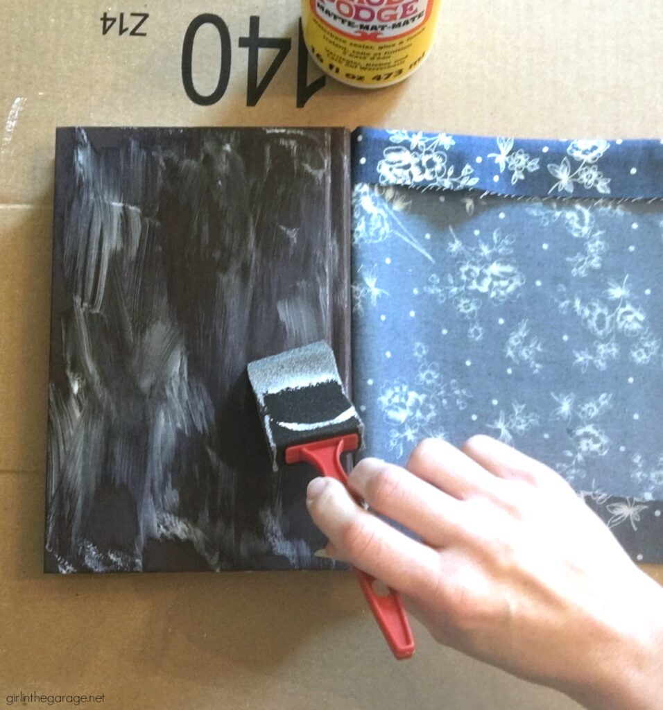 Learn how to decoupage fabric onto books and create gorgeous budget-friendly DIY home decor with this step by step tutorial from Girl in the Garage.