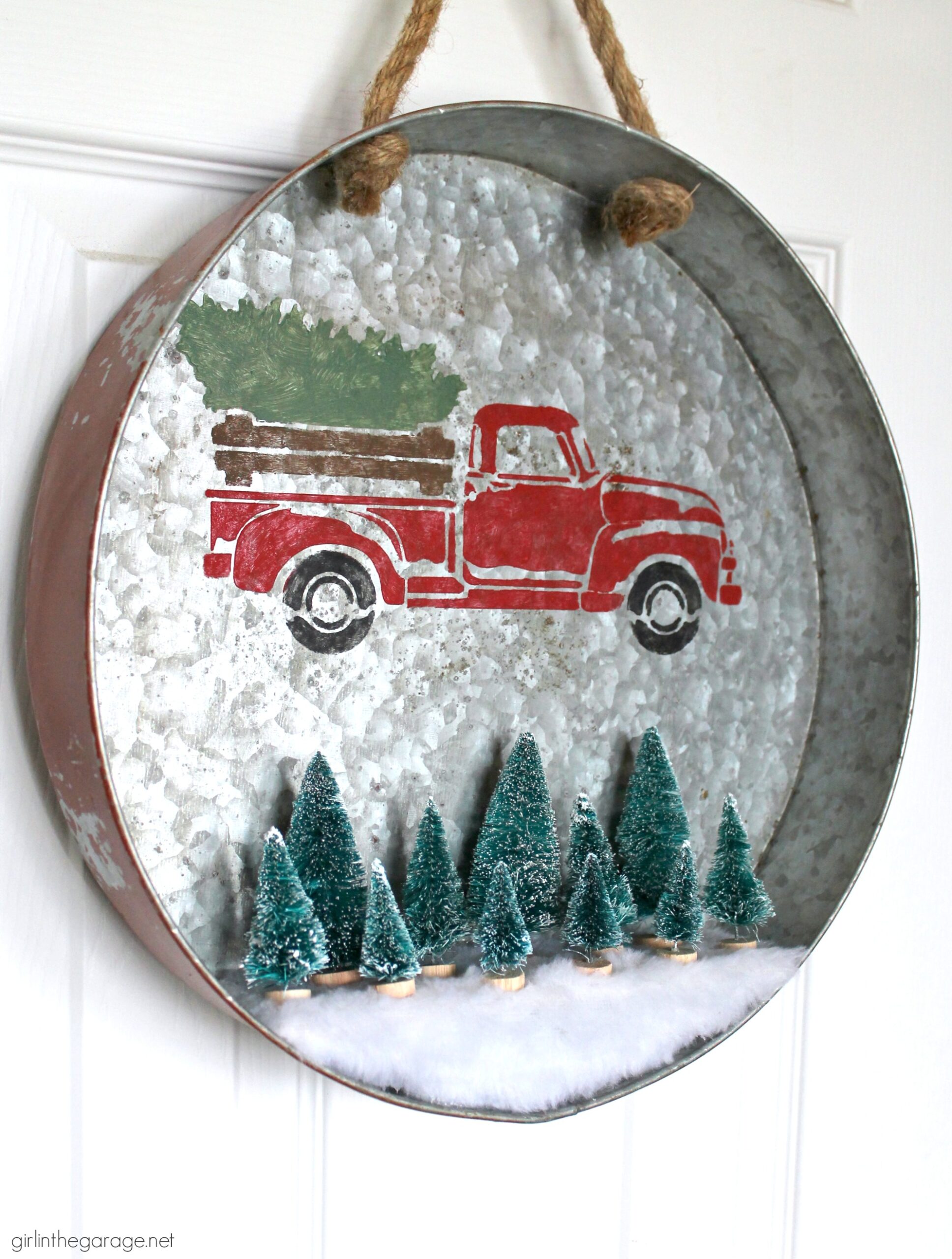 Make a DIY Christmas wreath from a repurposed metal tray - an adorable Christmas decor idea with stenciled truck and miniature bottle brush trees! By Girl in the Garage