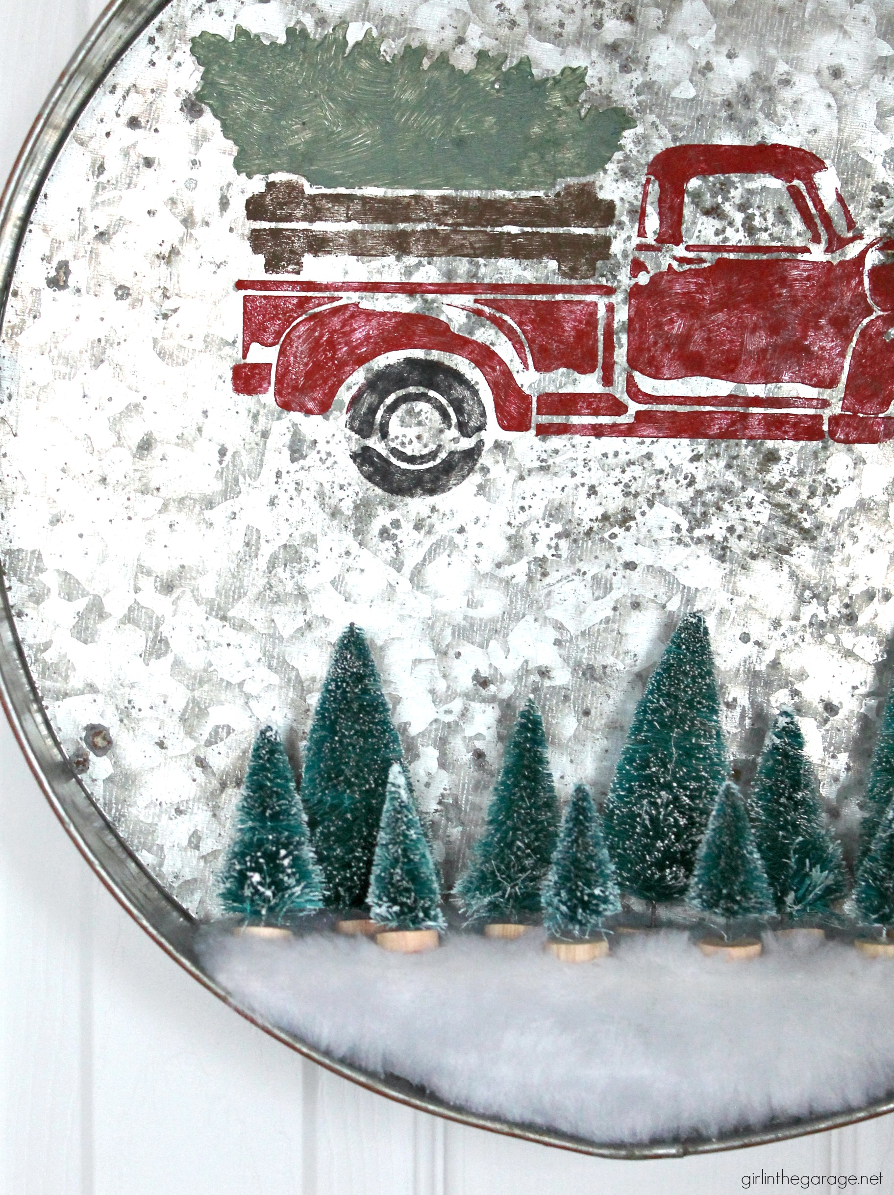 Make a DIY Christmas wreath from a repurposed metal tray - an adorable Christmas decor idea with stenciled truck and miniature bottle brush trees! By Girl in the Garage