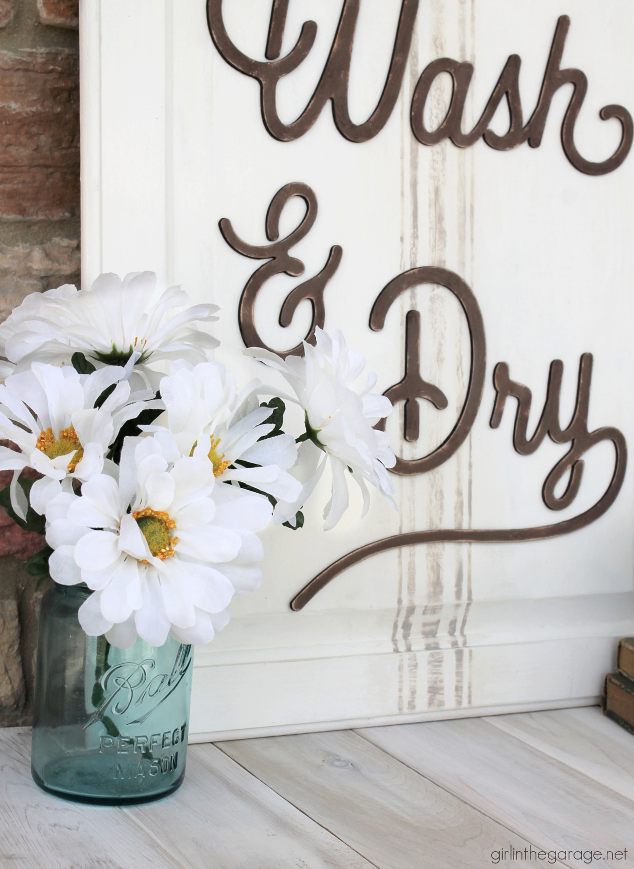 Have an old cabinet door? Learn how to repurpose it into an adorable DIY laundry room sign with grain sack stripes! By Girl in the Garage
