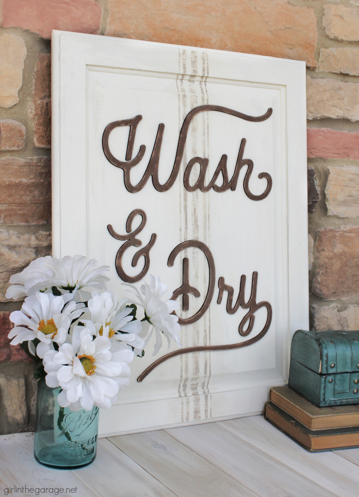 Have an old cabinet door? Learn how to repurpose it into an adorable DIY laundry room sign with grain sack stripes! By Girl in the Garage