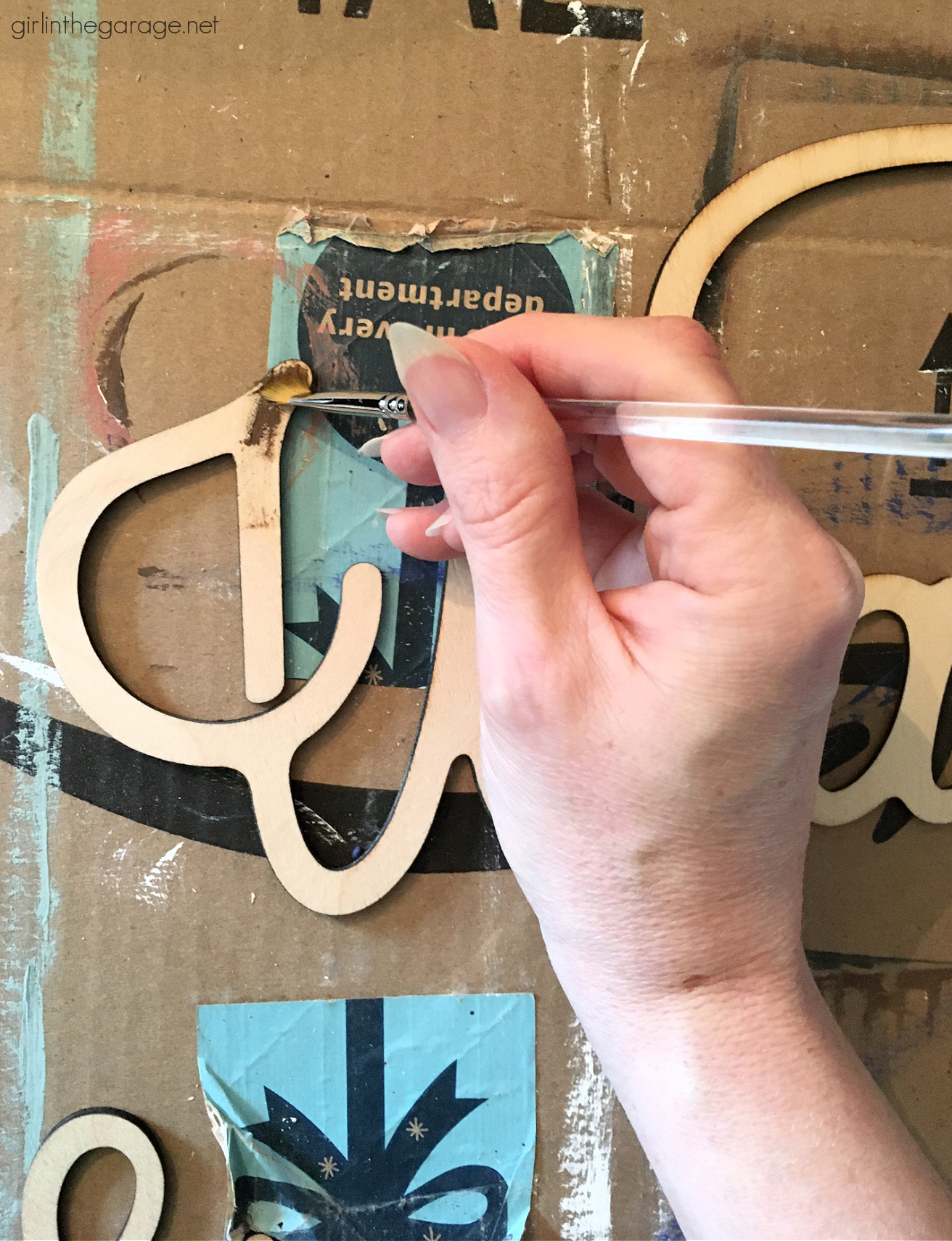 Learn how to repurpose an old cabinet door into an adorable DIY laundry room sign with grain sack stripes! By Girl in the Garage