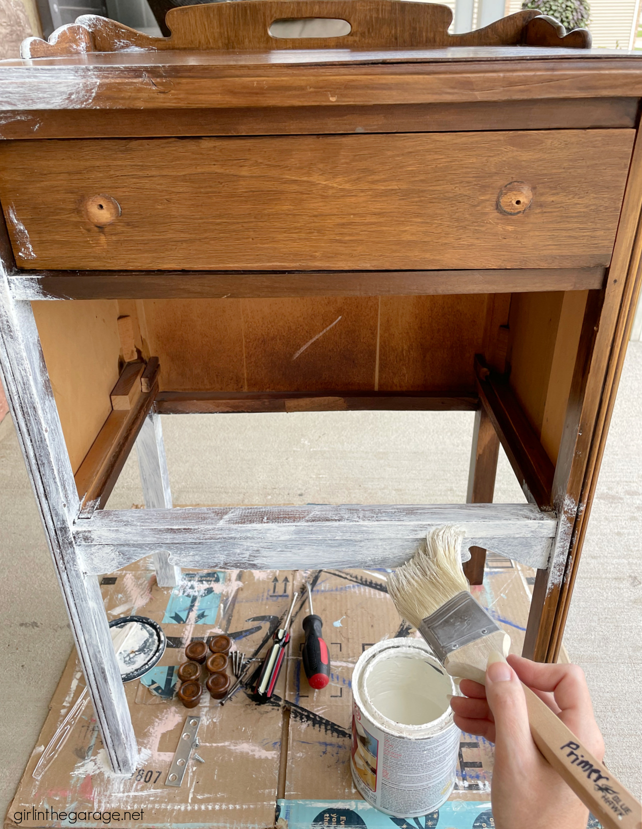 How to paint a vintage nightstand white and add charming decoupage poster board on the drawers. By Girl in the Garage
