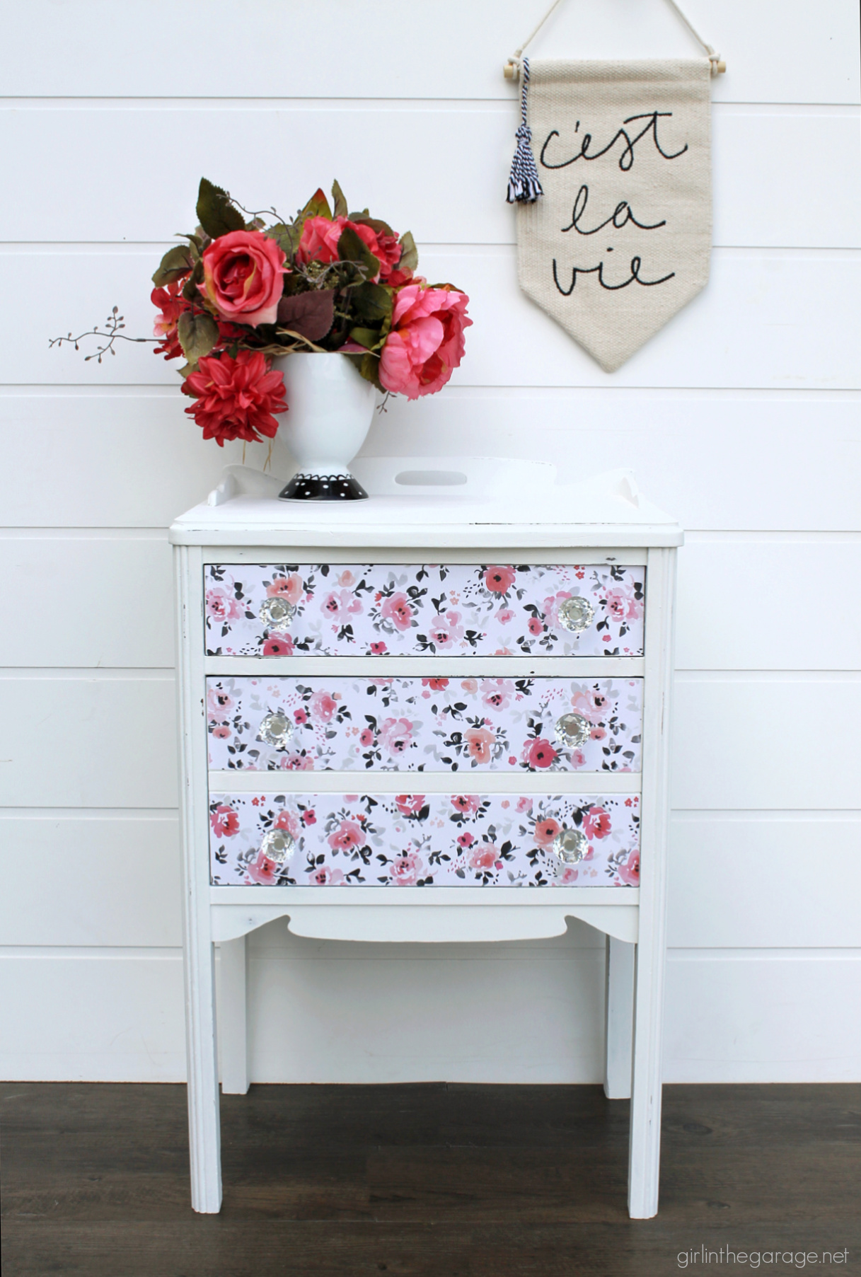 How to paint a vintage nightstand white and add charming decoupage poster board on the drawers. By Girl in the Garage