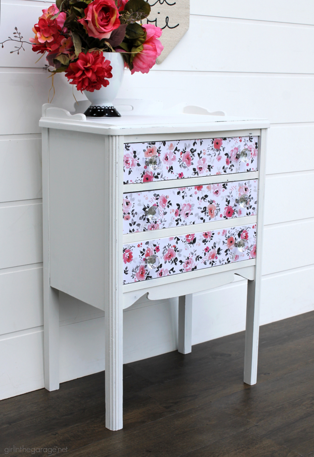 How to paint a vintage nightstand white and add charming decoupage poster board on the drawers. By Girl in the Garage