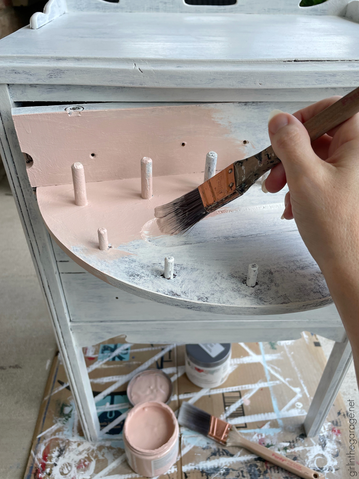 How to paint a vintage nightstand white and add charming decoupage poster board on the drawers. By Girl in the Garage