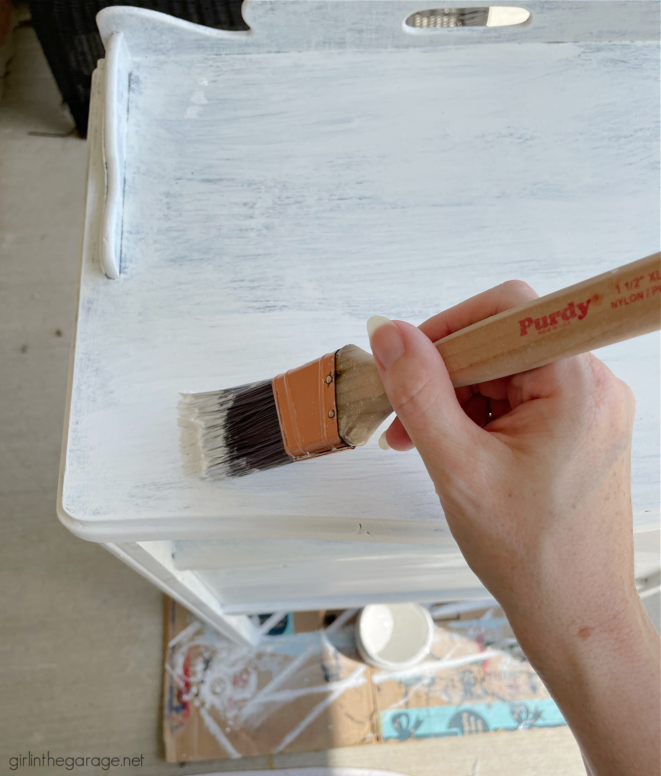 How to paint a vintage nightstand white and add charming decoupage poster board on the drawers. By Girl in the Garage