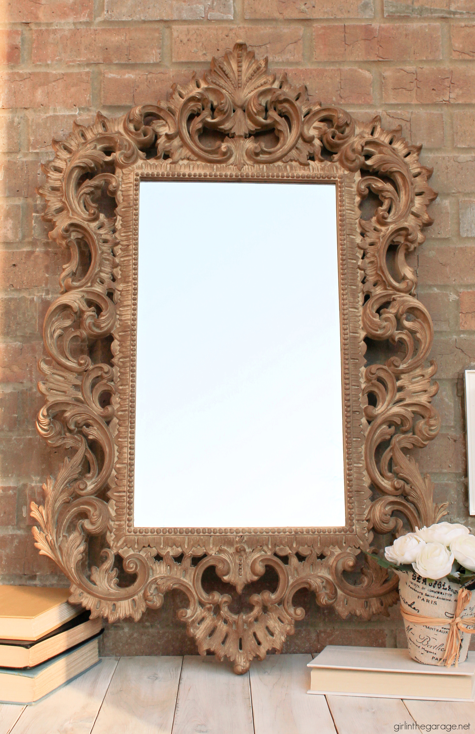 How to paint something to look like wood, like this gaudy gold plastic mirror. This easy makeover is a stunning update! By Girl in the Garage