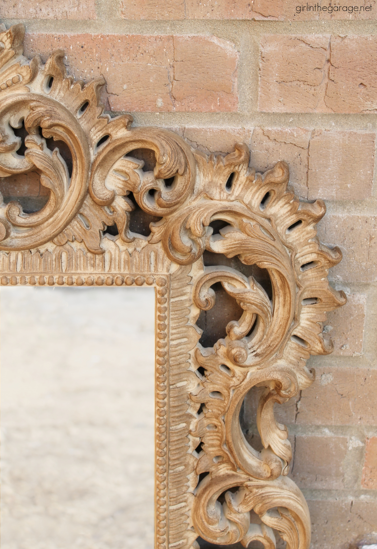 How to paint something to look like wood, like this gaudy gold plastic mirror. This easy makeover is a stunning update! By Girl in the Garage